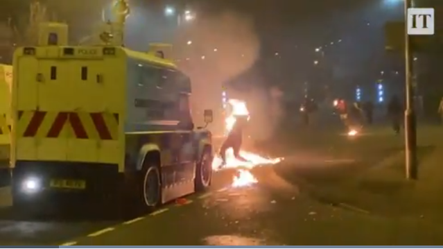 Протестующий, оказавшийся в зоне падения коктейля Молотова, брошенного в полицейскую машину, охвачен огнем