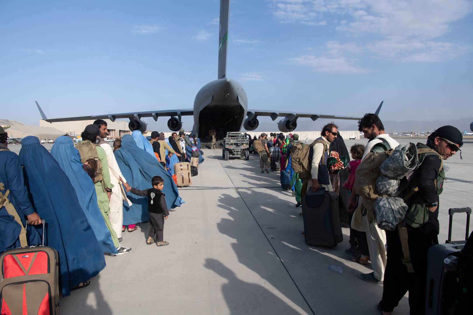 Афганцы садятся на борт самолета вооруженных сил США