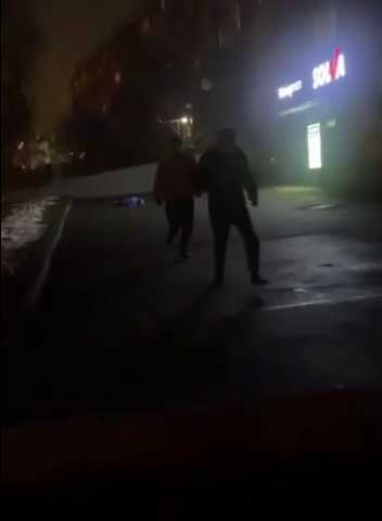 Бегущие от стрелкового боя жители Алма-Аты, на заднем фоне на земле лежит человек