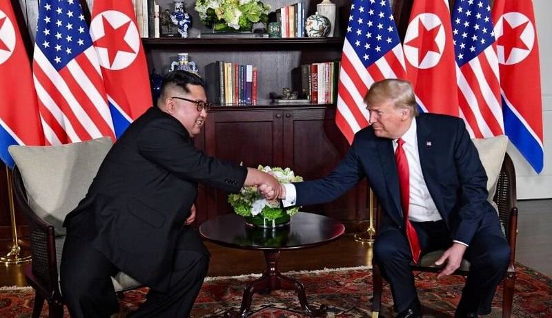 Трамп и Ким пожимают друг другу руки в зале саммита во время саммита КНДР-США в Сингапуре