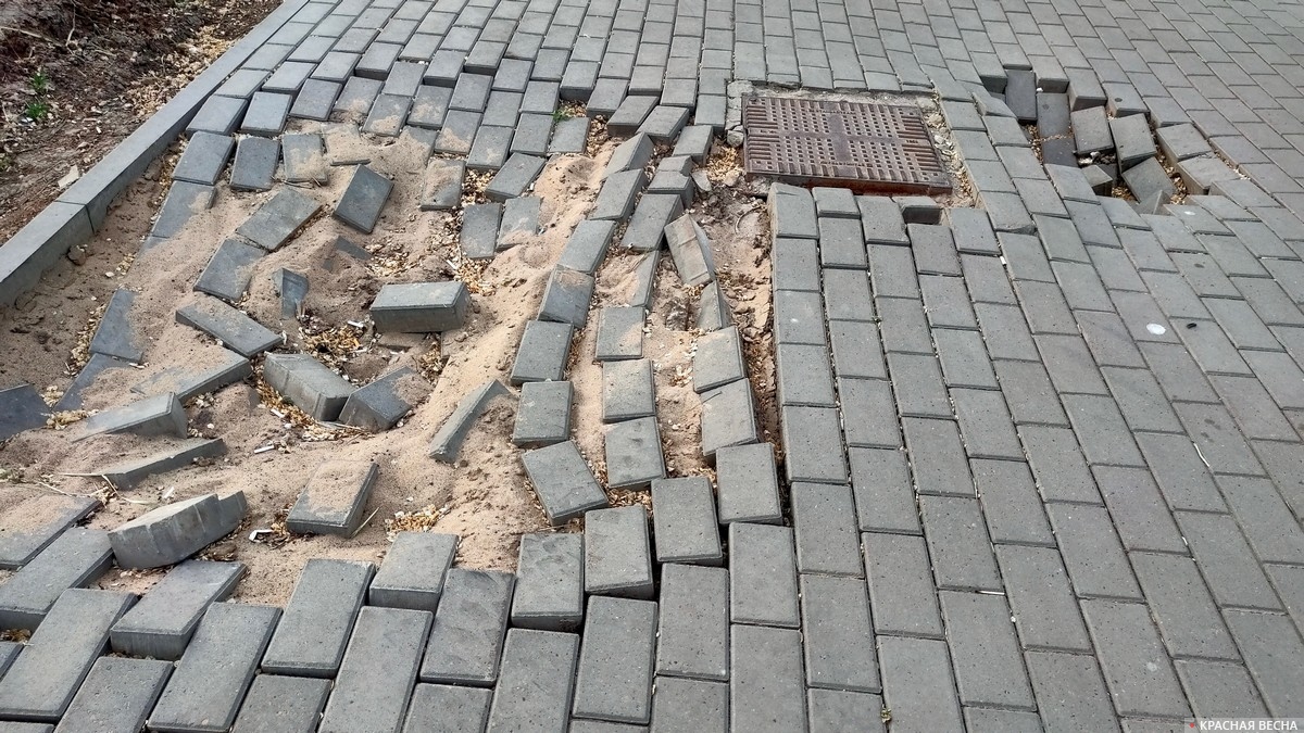 Провалившаяся тротуарная плитка.