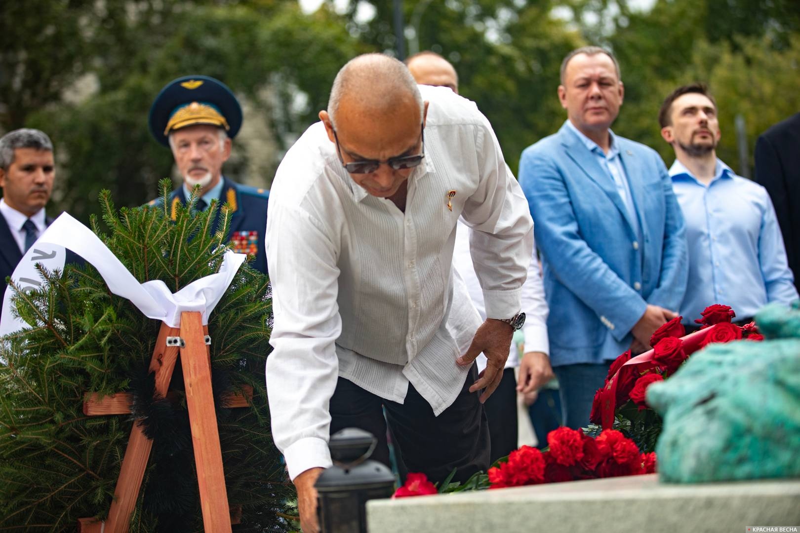 Герой Республики Куба Антонио Герреро возлагает цветы у памятника в торжественной обстановке, создатели монумента (справа)