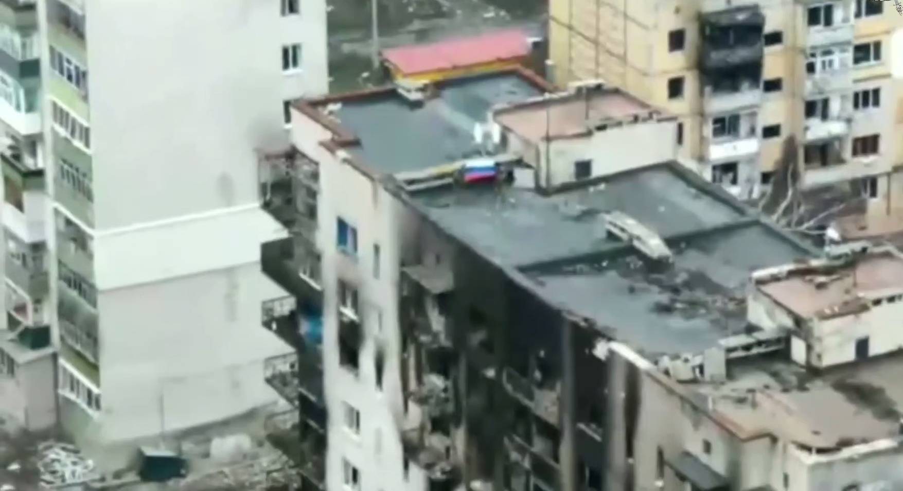 Двое бойцов ВС РФ развернули российский триколор на крыше многоэтажного дома в Купянске