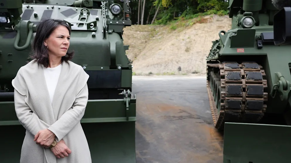 Глава МИД ФРГ Анналена Бербок перед отремонтированными танками и новыми машинами во время визита на оборонное предприятие во Фленсбурге