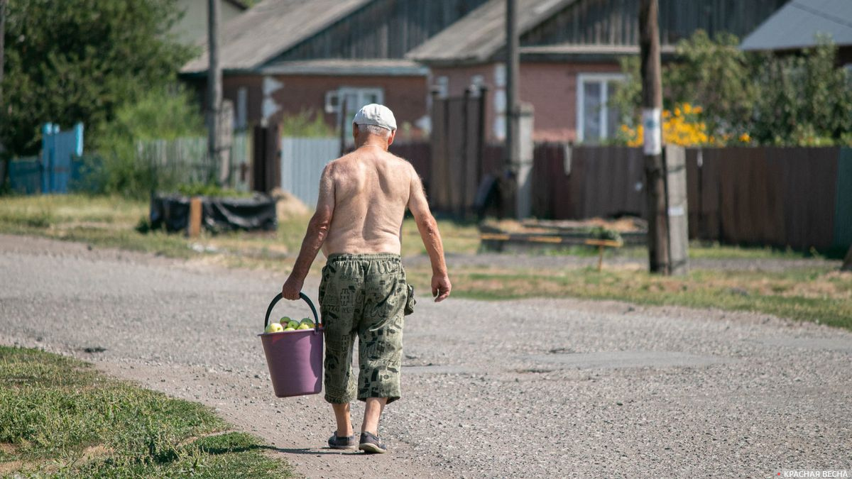 Старик несет яблоки на продажу