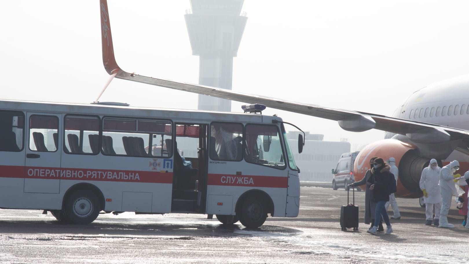 Граждане Украины, прибывшие из Уханя, выходят из самолета и садятся в автобус. 20.02.2020