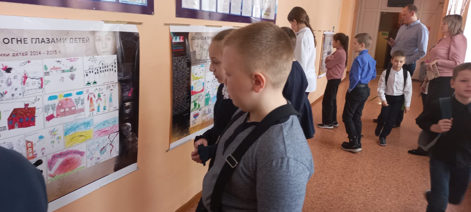 Дети Атамановской школы смотрят рисунки детей Донбасса
