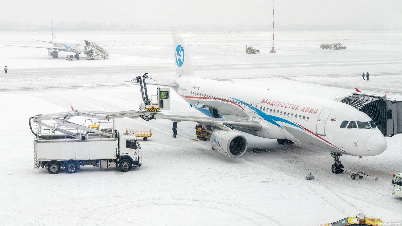 Подготовка самолёта Airbus 320 к вылету во время снегопада 