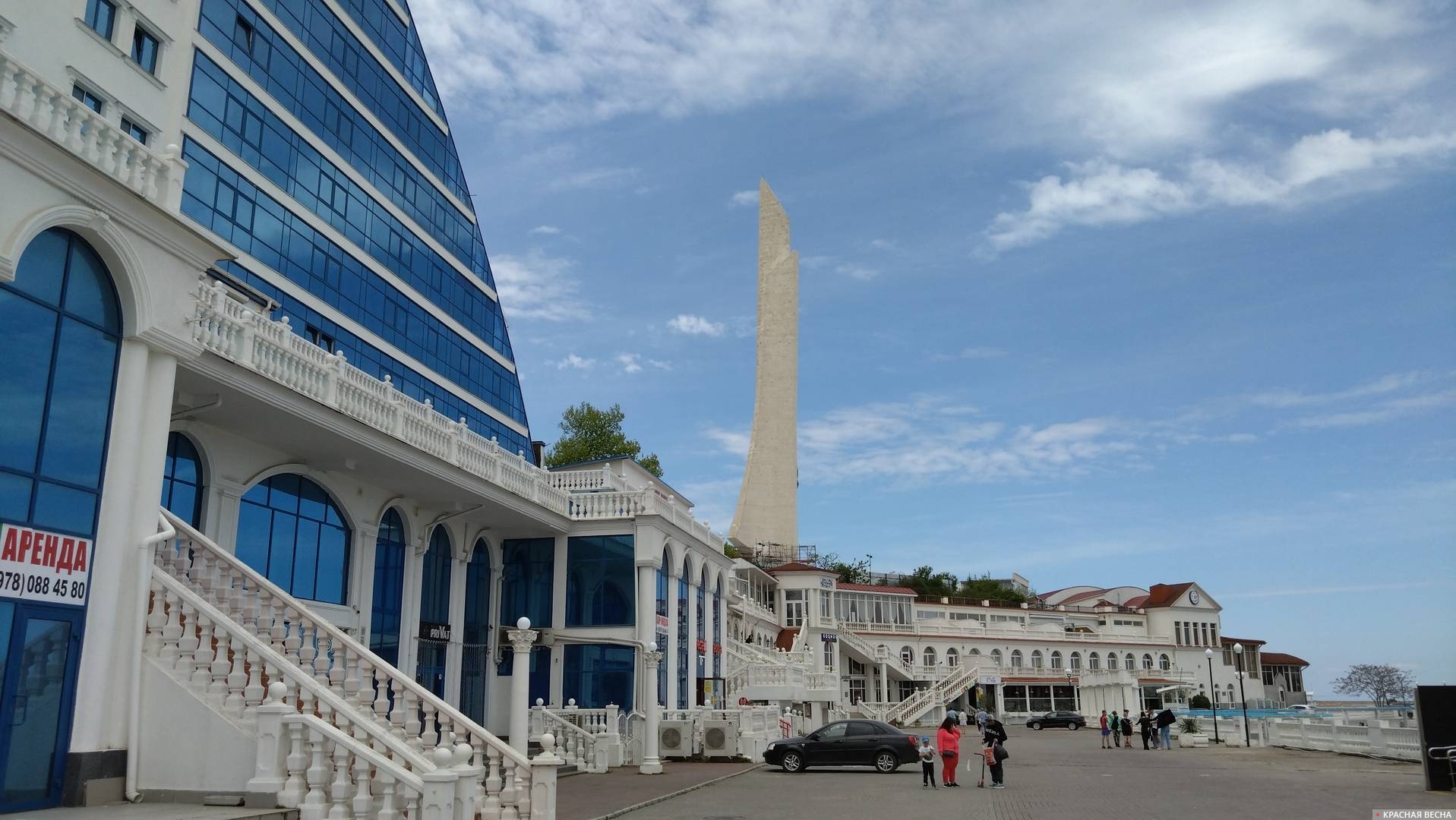 Огромное здание на мысе Хрустальном в Севастополе, за ним - обелиск 