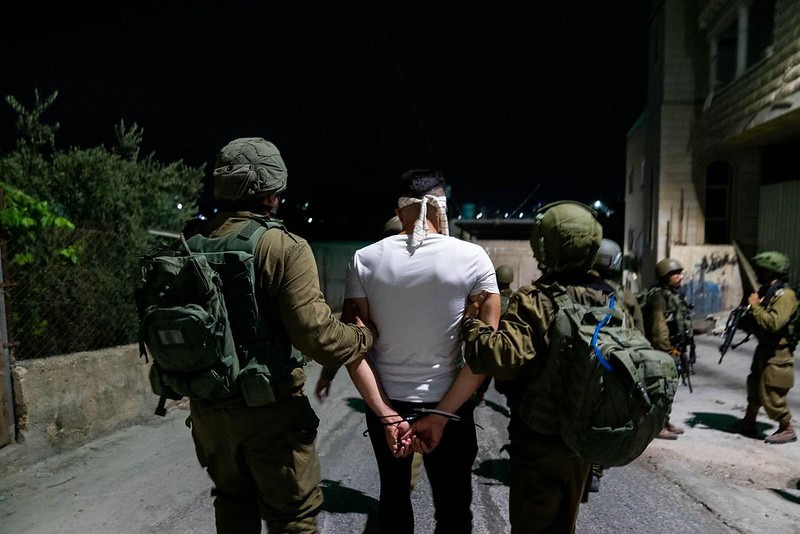 Израильские военные с задержанным палестинцем