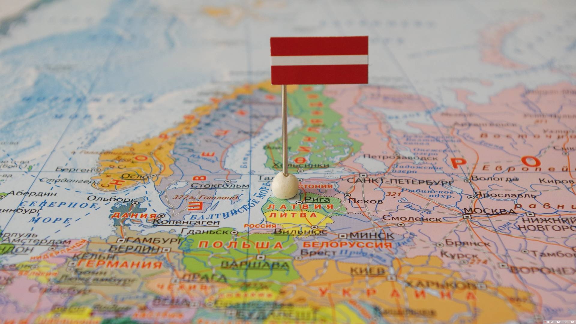 Латвия с флагом на карте мира