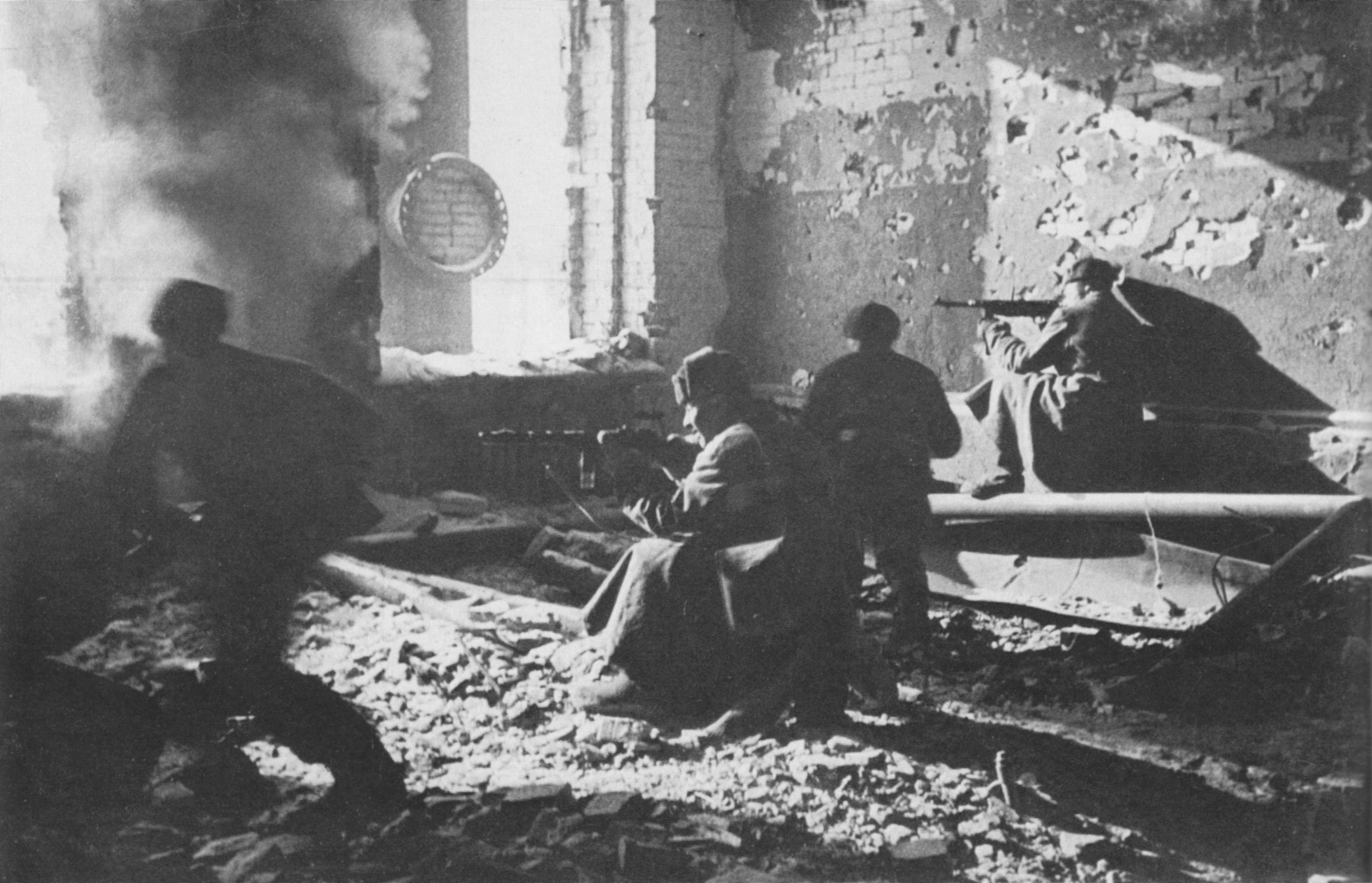 Минутой ранее. Советские бойцы ведут огонь из окон разрушенного здания в Сталинграде. 1942