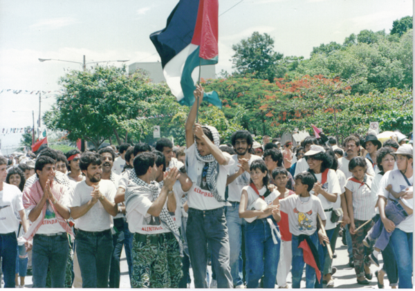 Палестинцы маршируют с флагами Палестины и СФНО в 1989 году.
