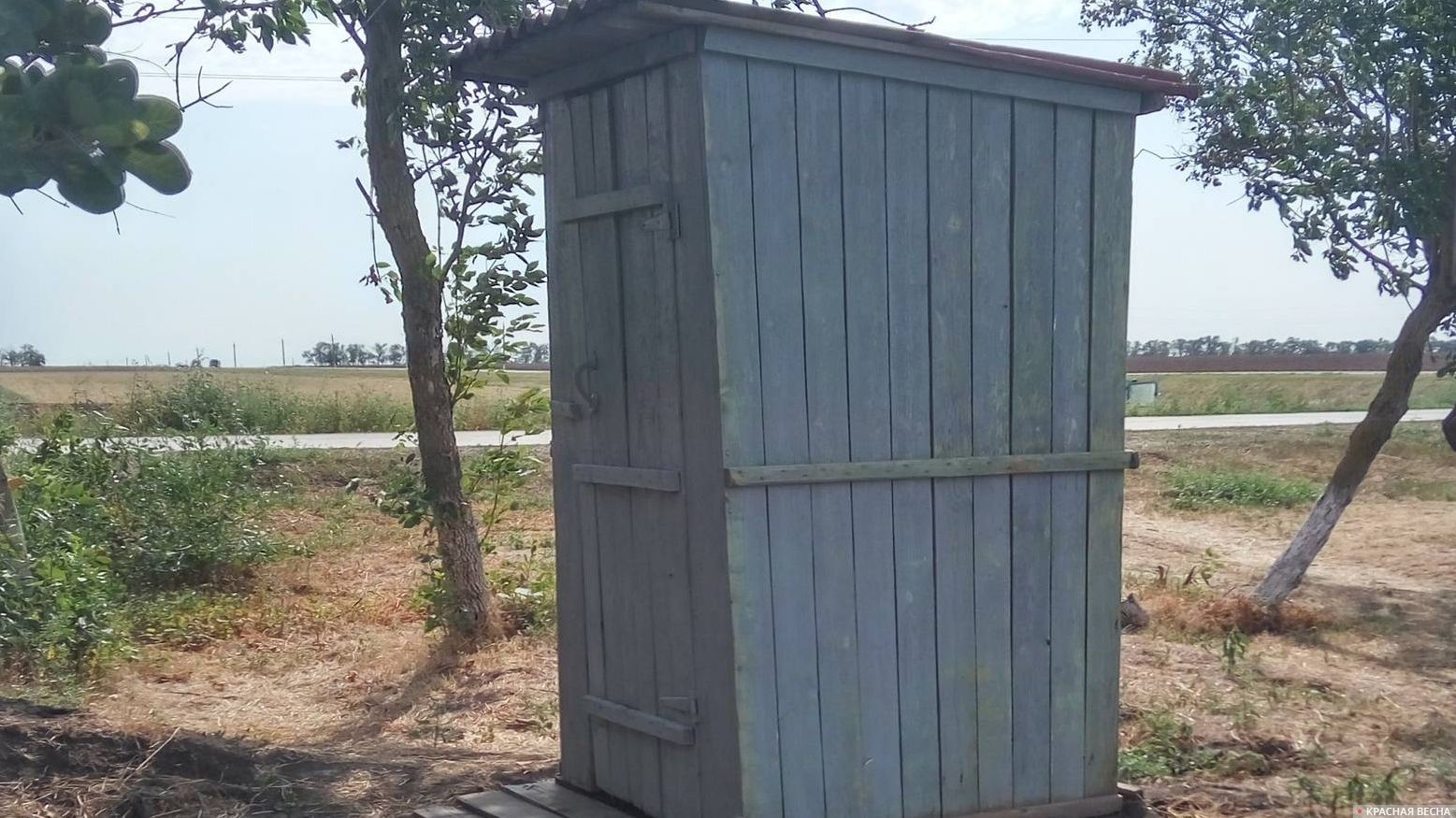 Деревянный туалет в поле
