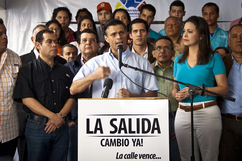 Мария Корина Мачадо (справа) в 2014 году на мероприятии с участием Леопольда Лопеса (на трибуне) оппозиционера, осужденного за терроризм и эвакуированного Испанией на свою территорию, и Хуана Гуайдо - впоследствии - самопровозглашенного президента Венесуэлы, ныне проживает в США