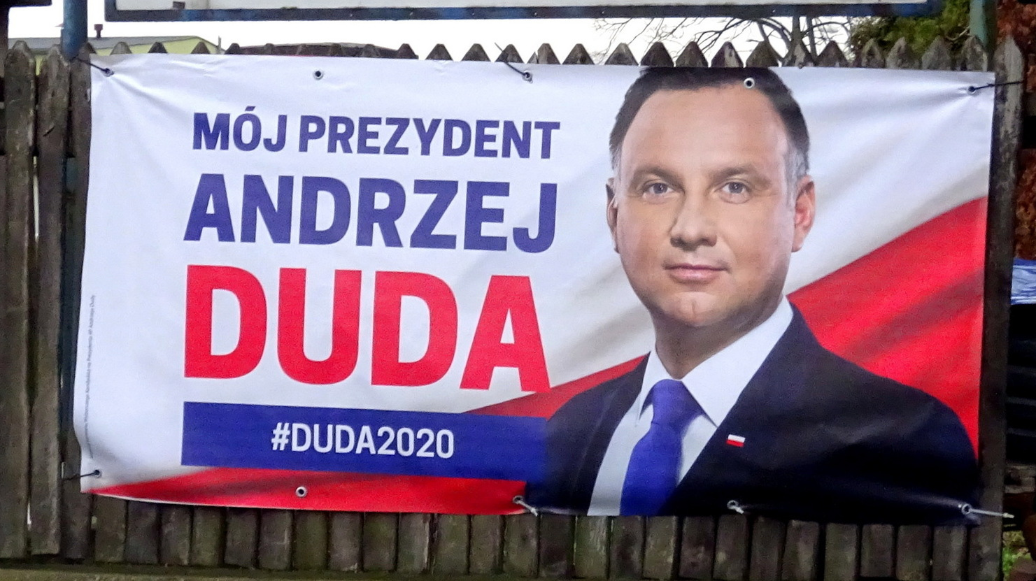 Избирательный плакат Анджея Дуды на заборе