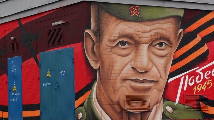 Граффити с изображением советского солдата в пилотке с перевернутыми советским символом и немецкими погонами