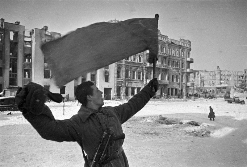 Красноармеец с красным знаменем на площади Павших борцов в Сталинграде, после окончания боев. Январь-февраль 1943
