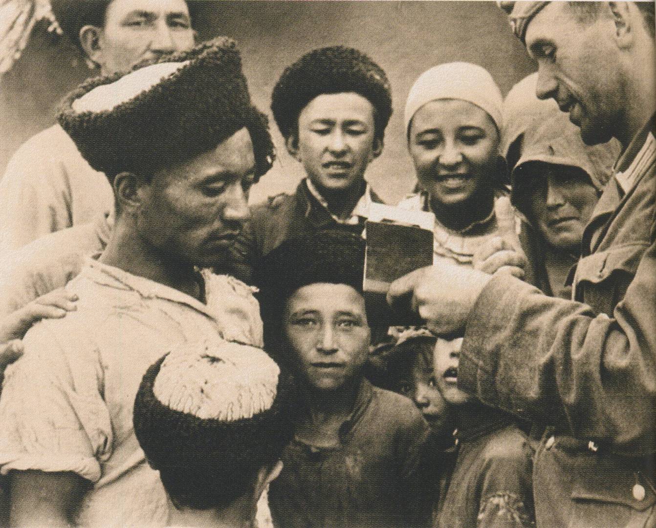 Немецкий солдат в окружении крымских татар. 1942 год