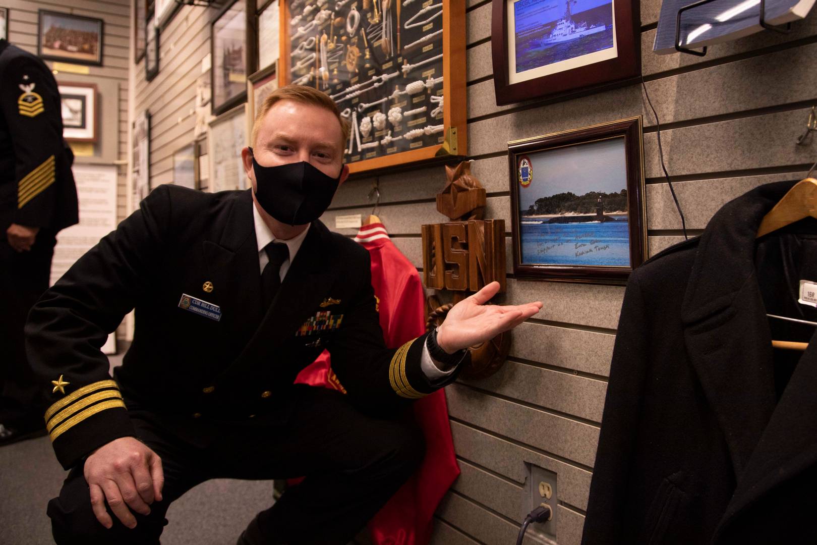 Командир подводной лодки «Аляска», позирует на фоне фотографии «Аляски» в музея ветеранов Аляски в городе Анкоридж, Аляска