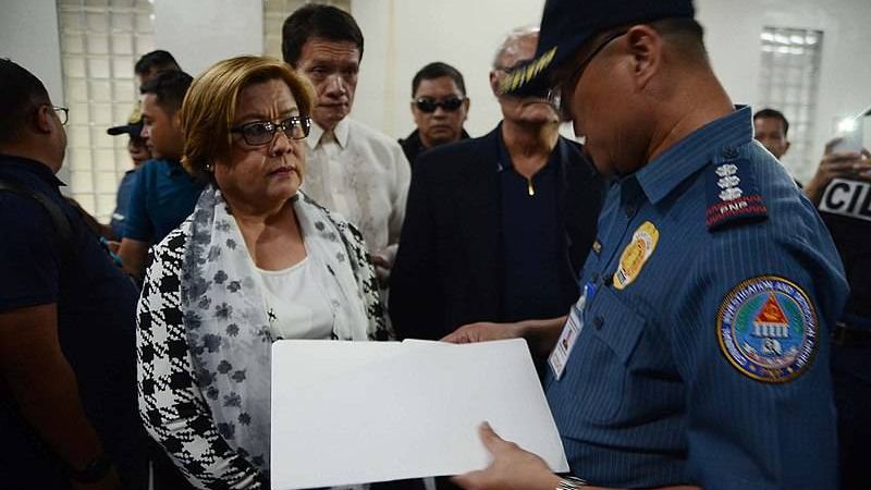 Сенатор Лейла де Лима слушает офицера c ордером на ее арест