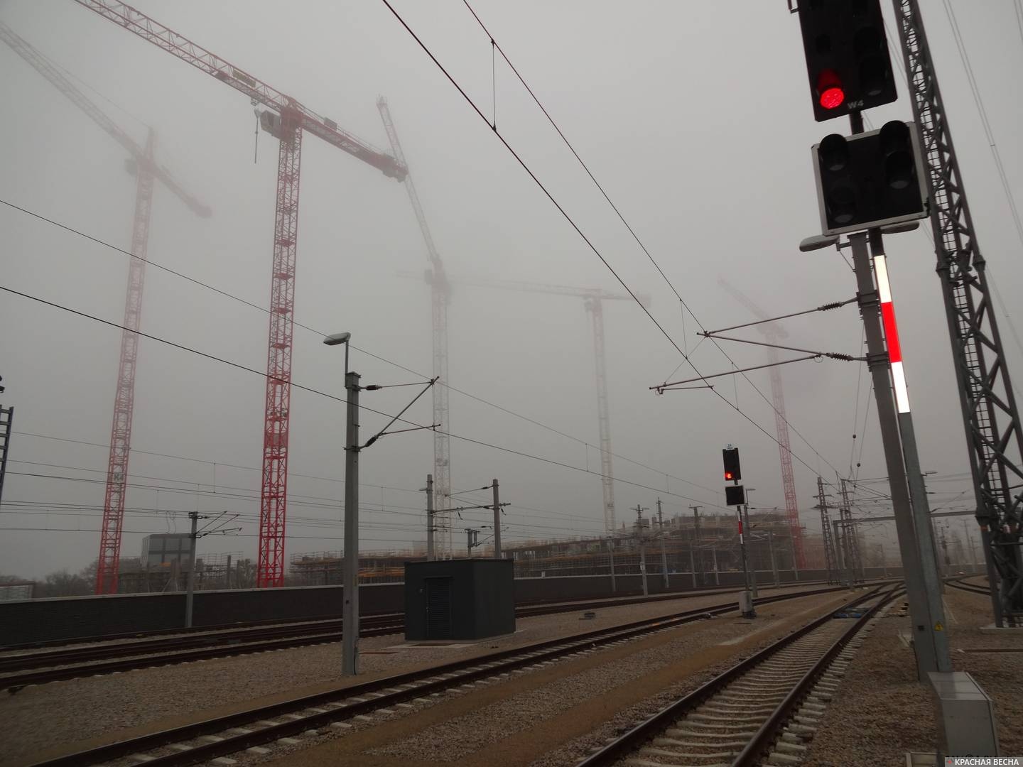 Подъёмные краны в тумане и железная дорога