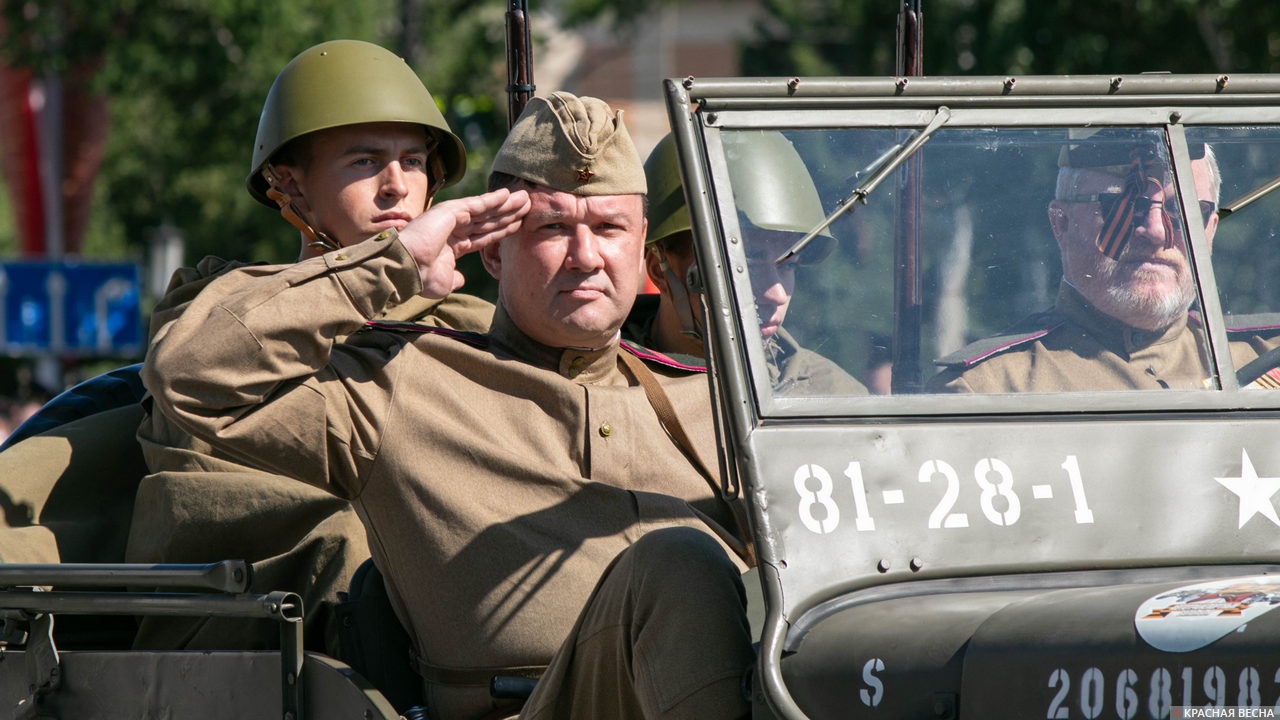 Люди в советской форме в американском автомобиле времен войны на параде Победы
