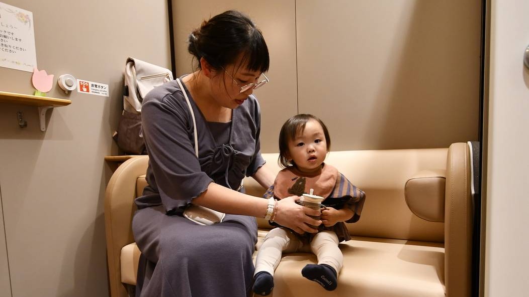 Японка с ребенком в детской комнате метро