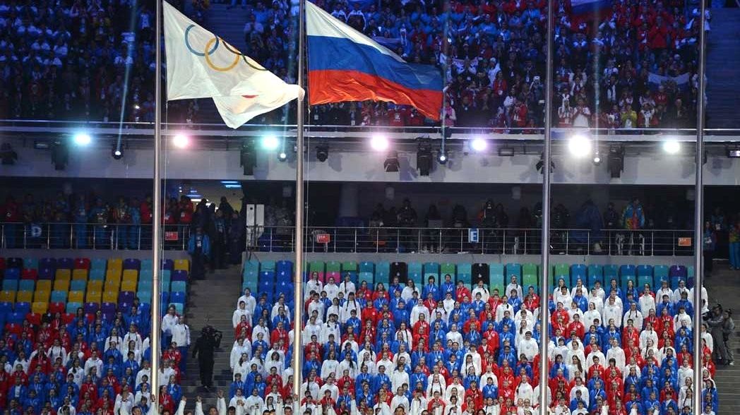 Олимпийский и российский флаги на церемонии закрытия Олимпийских игр — 2014