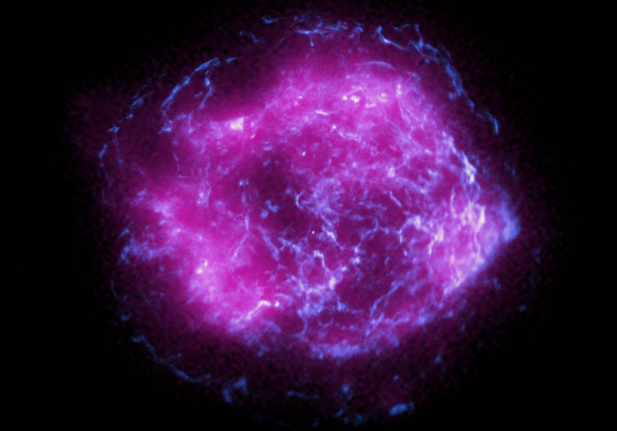 Это изображение сверхновой Кассиопеи А сочетает в себе некоторые из первых рентгеновских данных, собранных IXPE, отображенных пурпурным цветом, с данными рентгеновского излучения высокой энергии из Рентгеновской обсерватории Chandra, выделенными синим цветом.