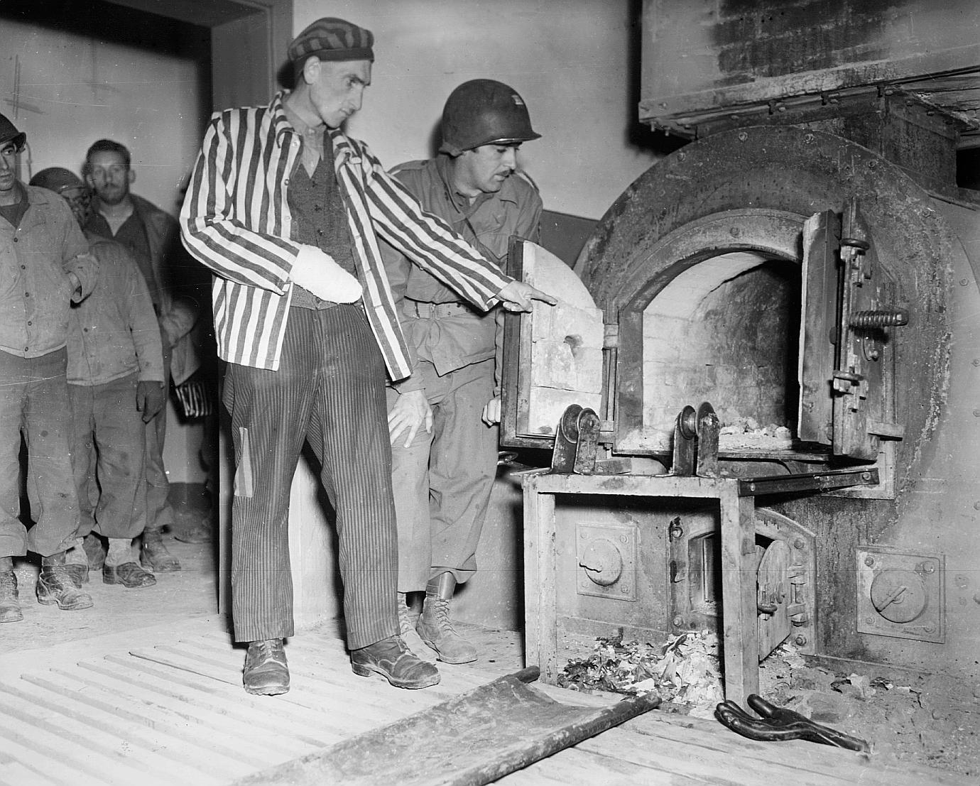 Заключенный лагеря Дора-Миттельбау (Нордхаузен) показывает американскому солдату лагерный крематорий