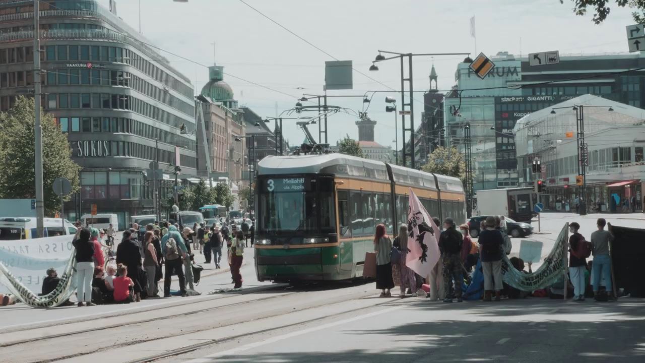 Активисты Elokapina пропускают трамвай на улице Маннерхейминтие. 17 июня 2021 года
