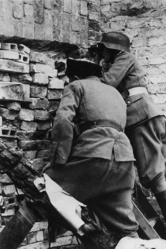 Казаки (в каске — казачий офицер) наблюдают за боем во время подавления Варшавского восстания 1944 года
