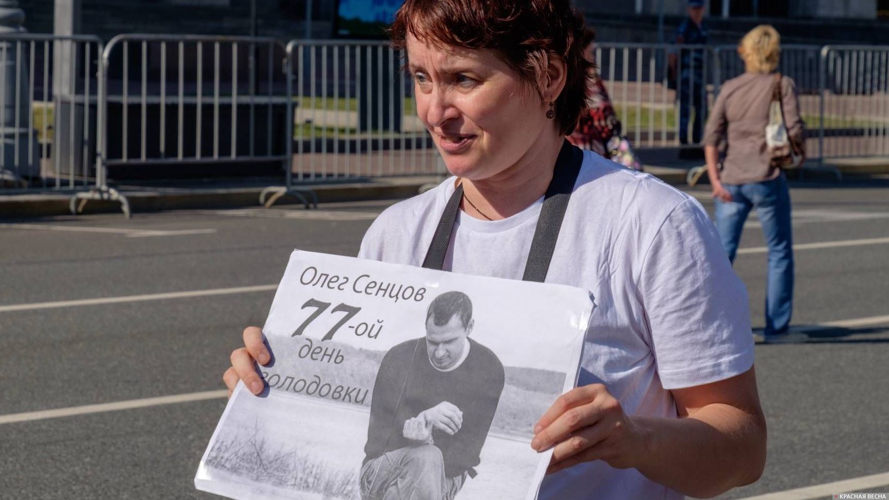 Женщина с плакатом «Олег Сенцов…» на проспекте Сахарова