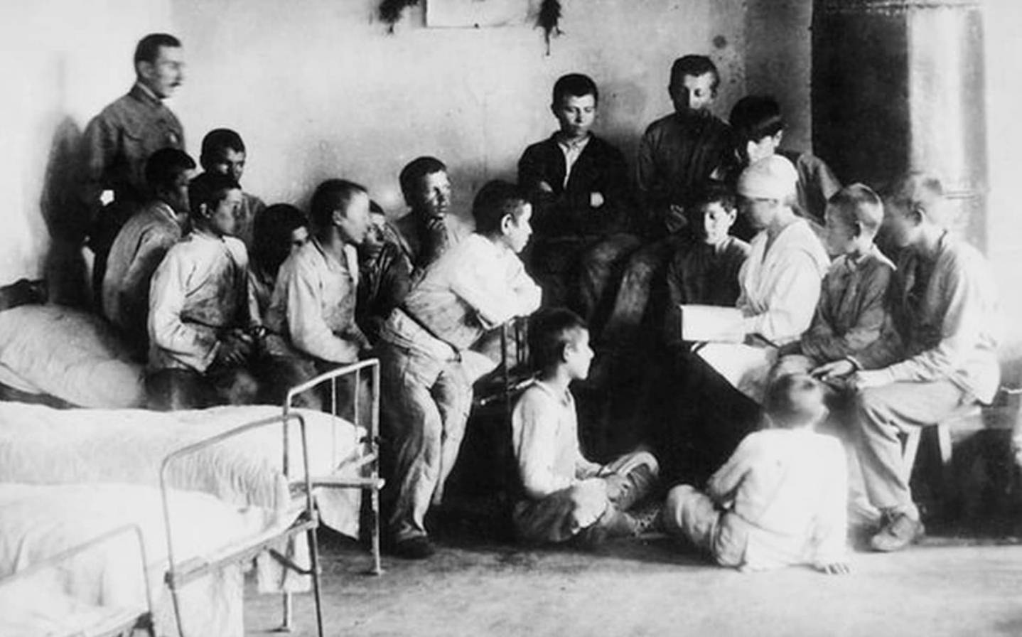 Чтение в спальне колонистов. Слева стоит А. С. Макаренко. 1921