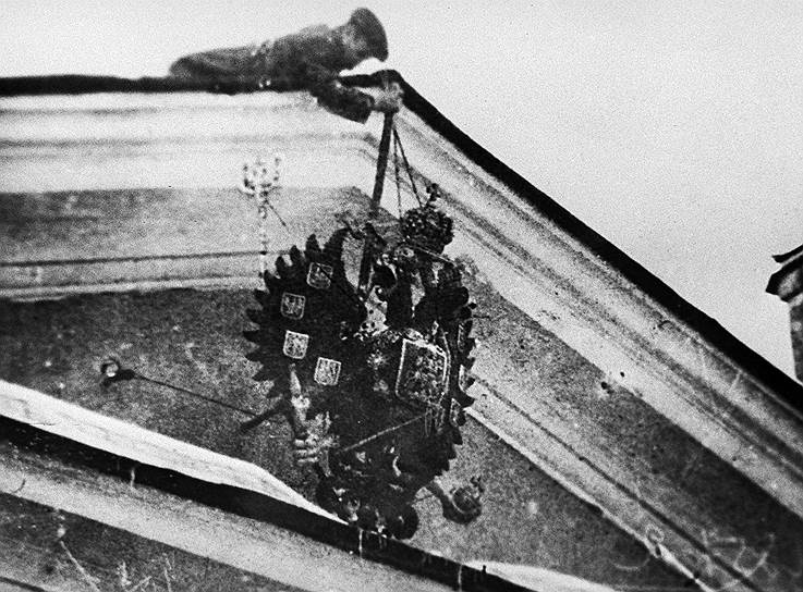 Революционер сбрасывает царский герб. 1917