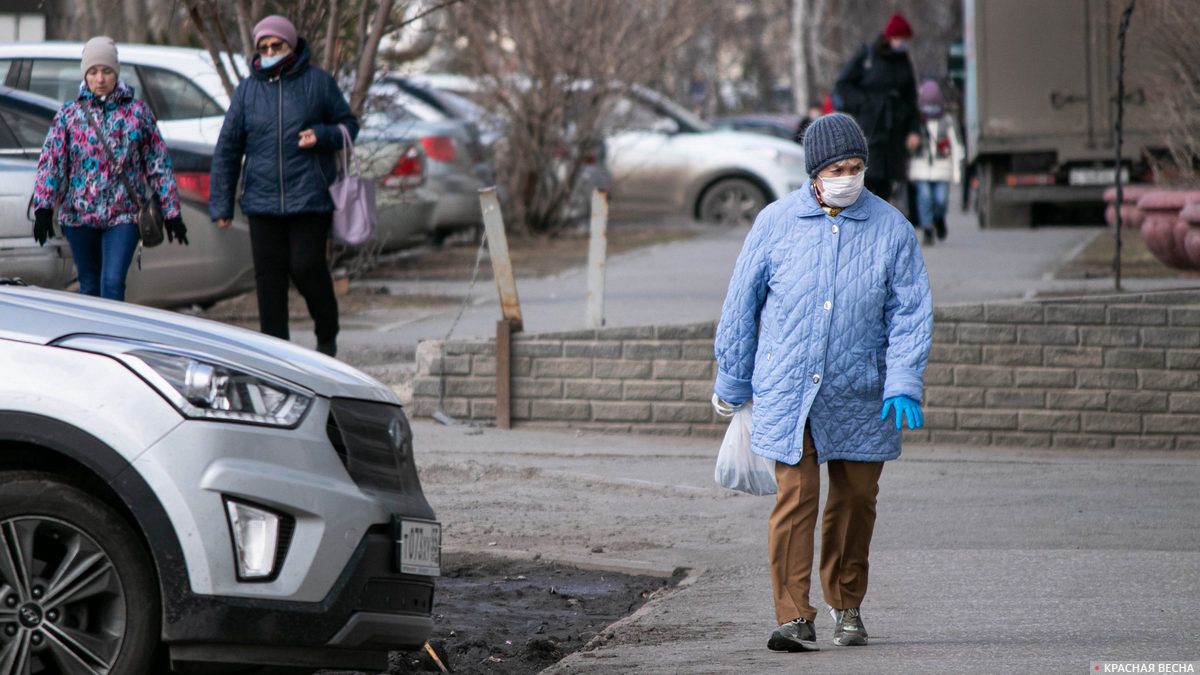 Пожилая женщина в медицинской маске и резиновых перчатках