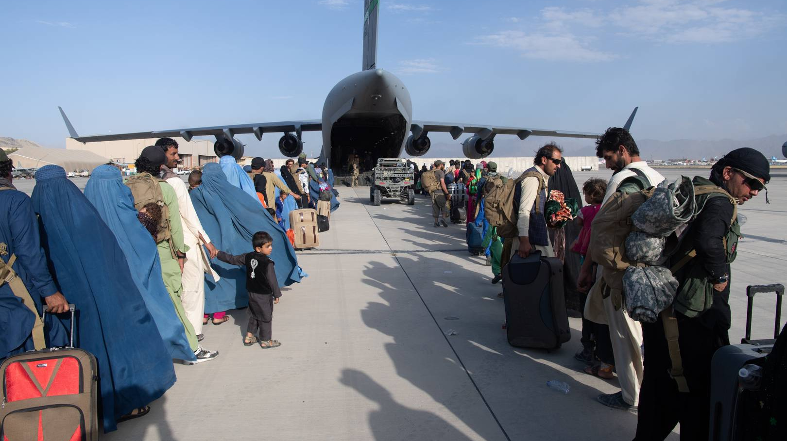 Афганцы садятся на борт самолета вооруженных сил США