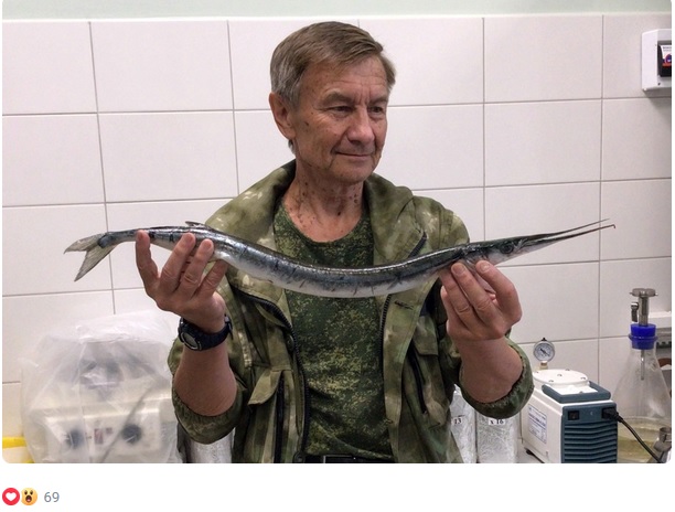 Геннадий Дворнякин держит рыбу сарган