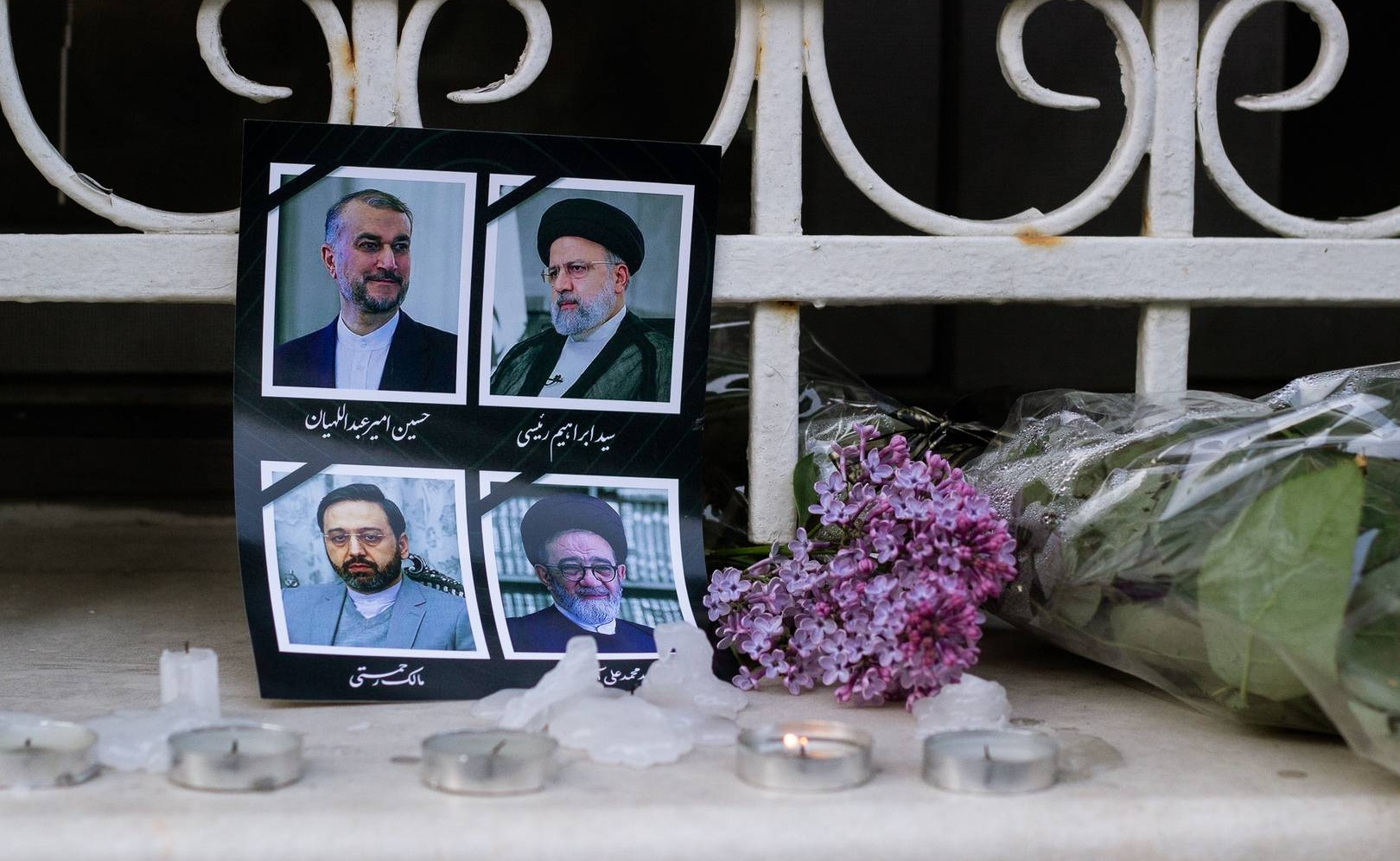 Цветы и свечи возле портретов погибших в авиакатастрофе государственных деятелей Ирана