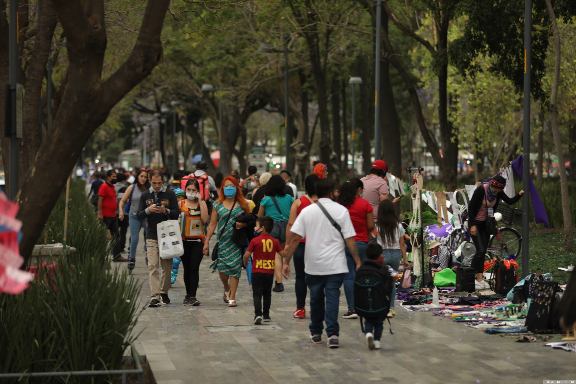 Мирные горожане, прогуливающиеся по центральному парку Аламеда рядом с лотками феминисток