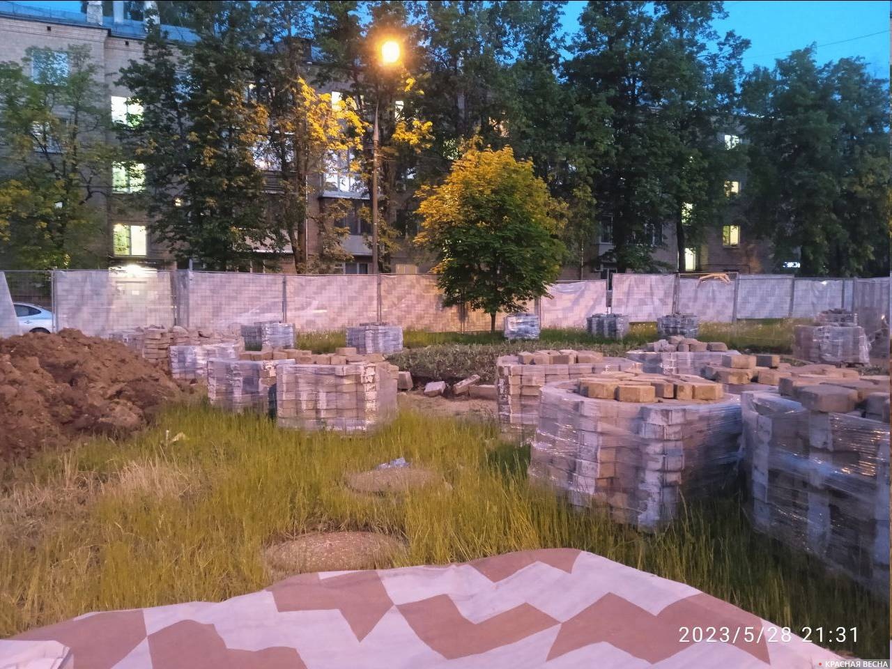Начатые земляные работы и подготовленная плитка на газоне улицы Главная Восточного поселка города Москвы