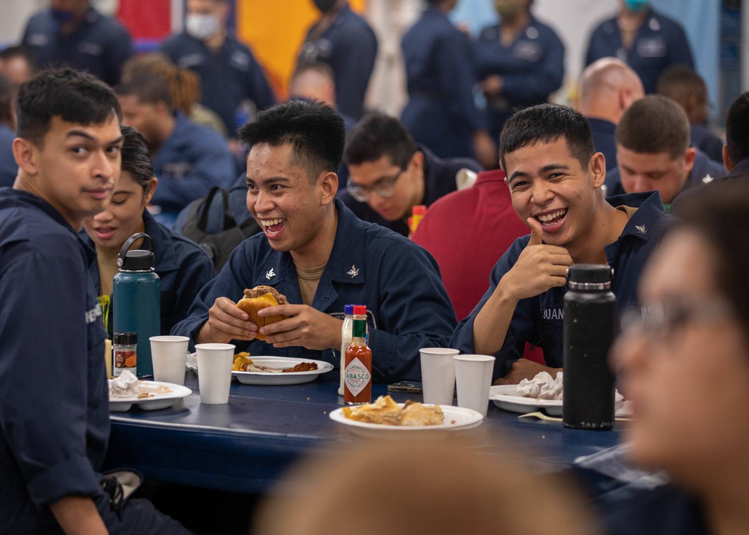 Моряки десантно-штурмового корабля Bataan (LHD 5) ВМС США демонстрируют хорошее настроение во время обеда в корабельной столовой