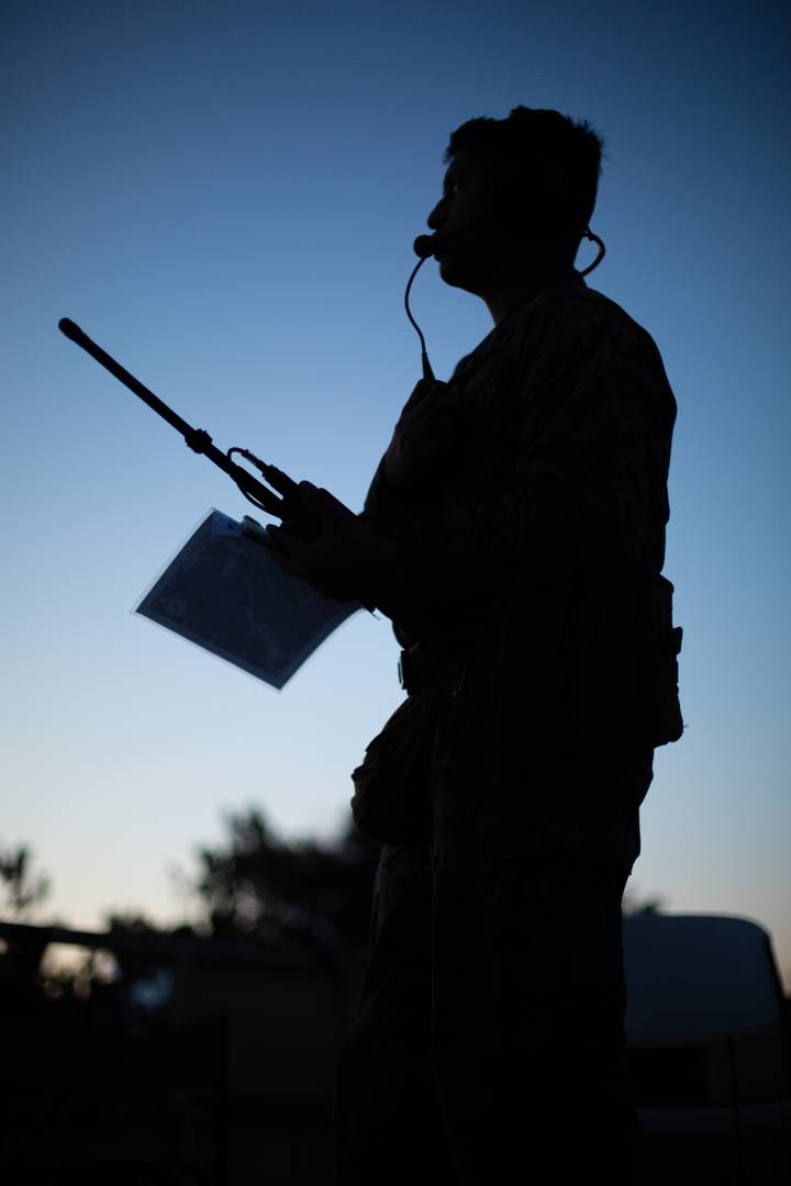 Американский морской пехотинец использует портативную радиостанцию для координации авиации и наземных сил КМП США