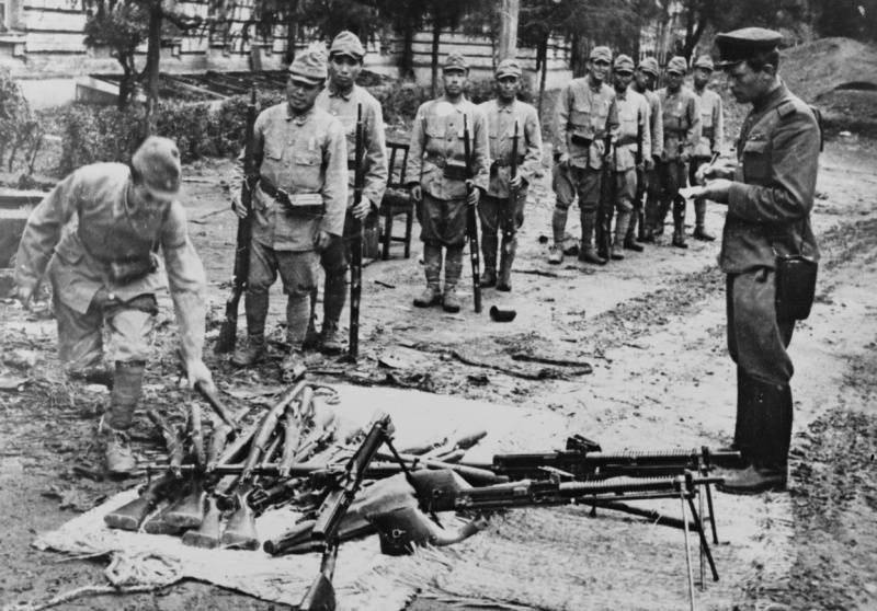 Японские солдаты сдают свое оружие советскому офицеру. 1945