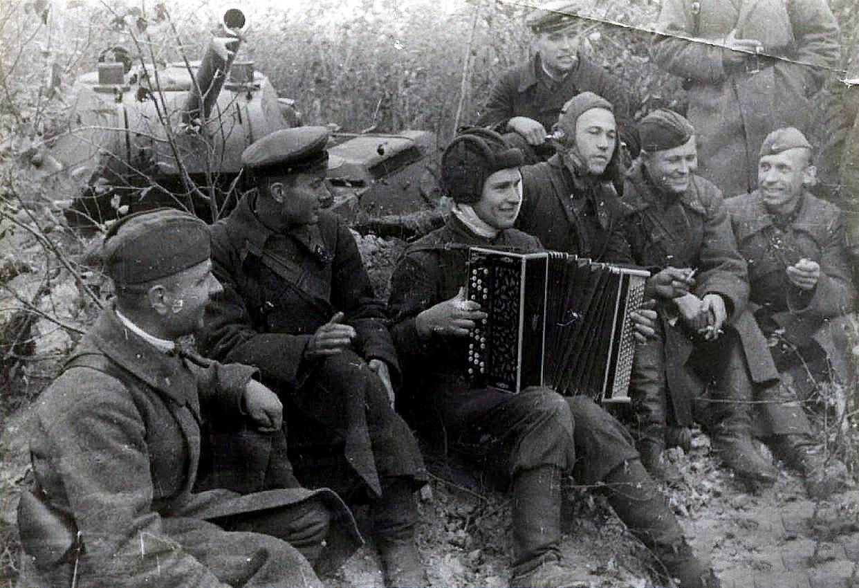 Советские солдаты и командиры слушают играющего на баяне танкиста. 1941