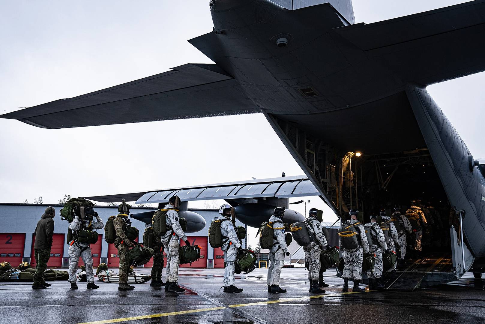 Финские военнослужащие из егерского полка UTI поднимаются на борт американского транспортного самолёта MC130-J Commando II. 30 января 2025 года