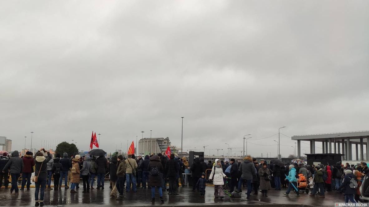 Люди собираются на митинг на фоне руин СКК