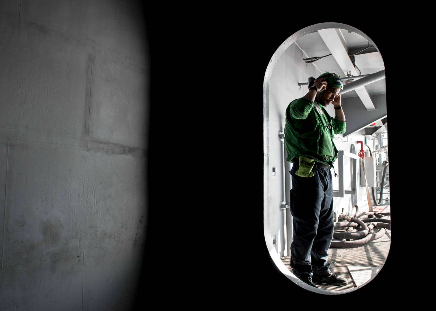 Моряк ВМС США поправляет средства защиты органов слуха