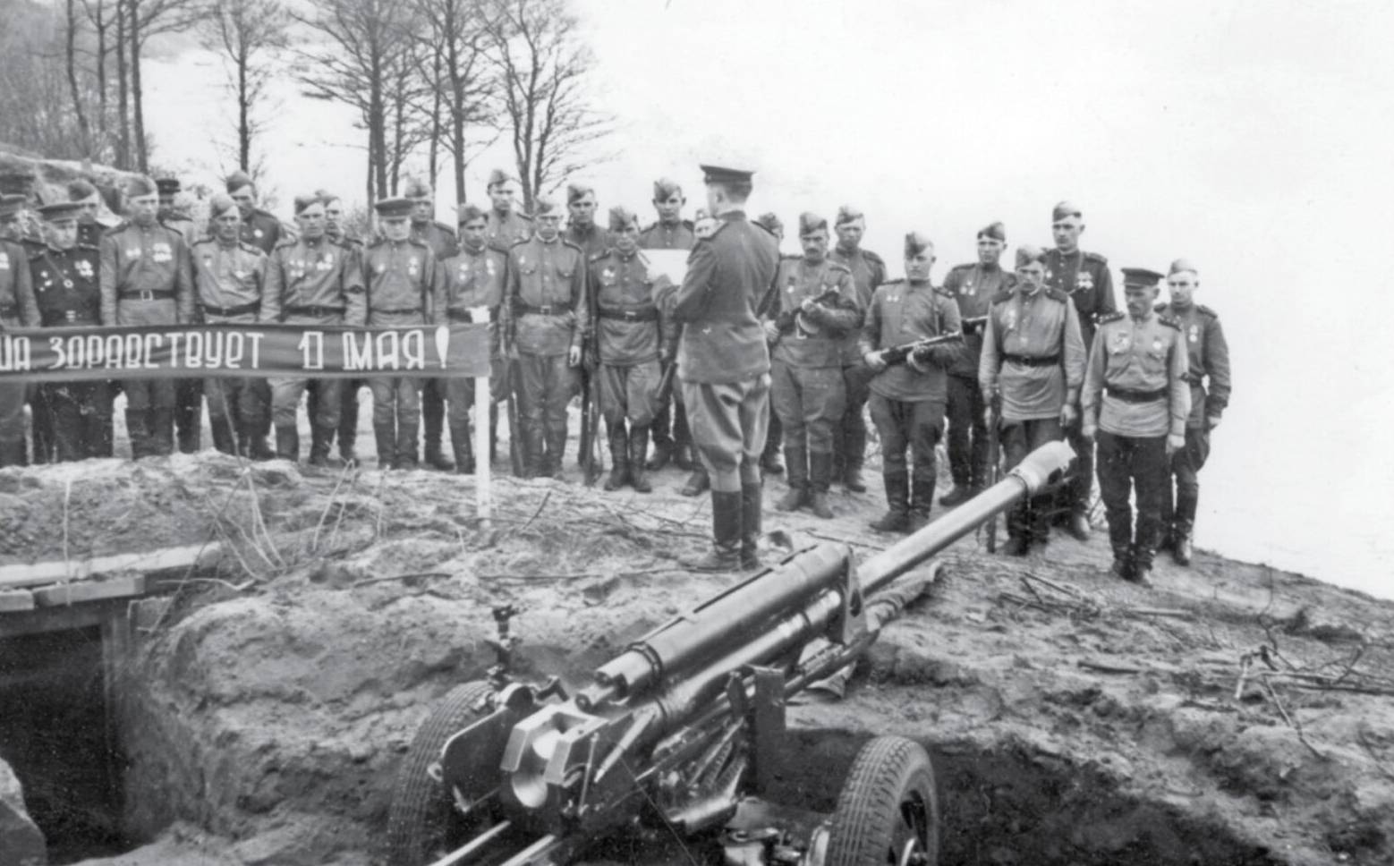 Гвардии капитан Савенков зачитывает артиллеристам первомайский приказ Сталина. Май 1945 г.